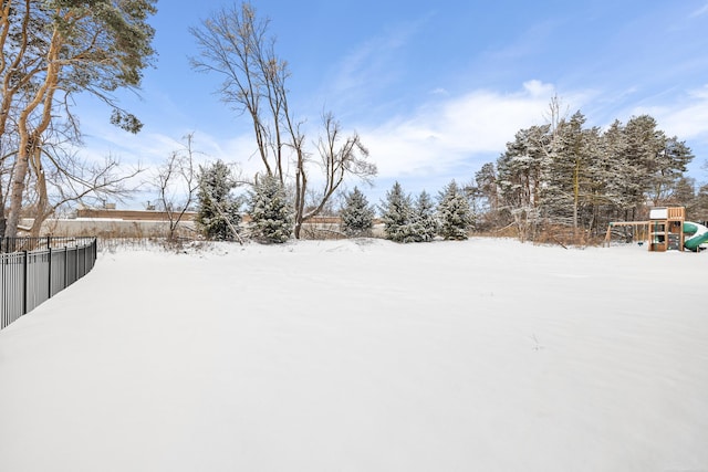 yard covered in snow with a playground