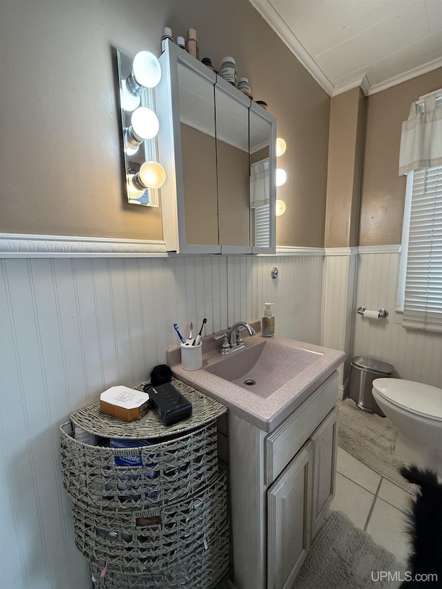 bathroom featuring tile patterned flooring, vanity, ornamental molding, and toilet