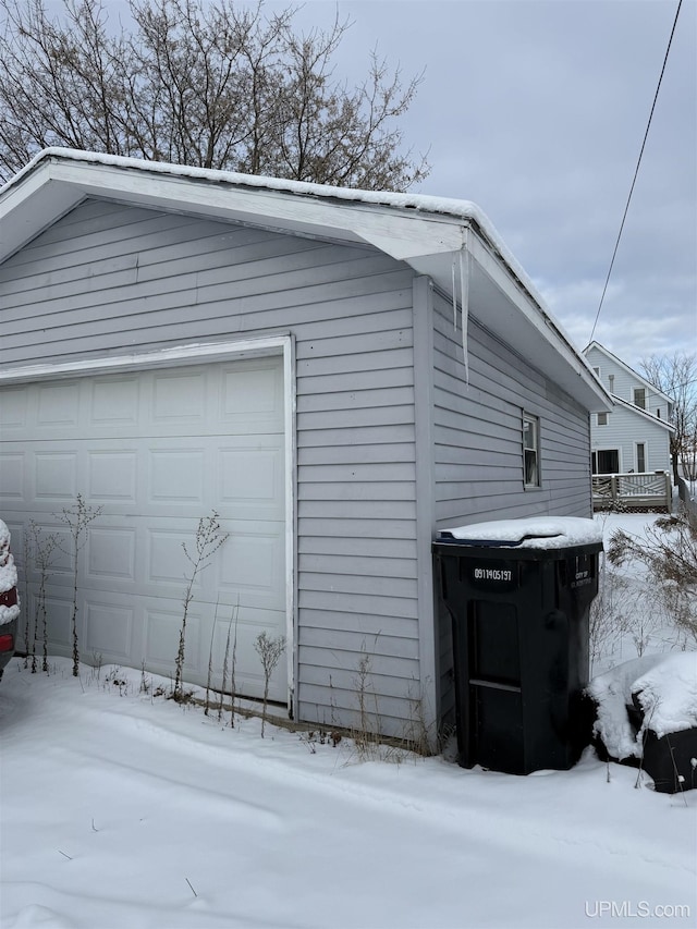 view of snowy exterior featuring a garage