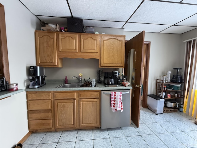 kitchen with sink, light tile patterned floors, a paneled ceiling, and dishwasher