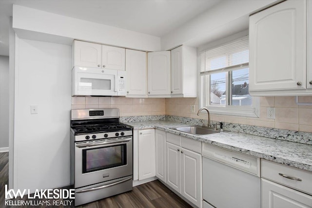 kitchen with sink, light stone counters, white appliances, decorative backsplash, and white cabinets