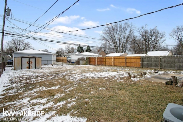 snowy yard featuring a shed