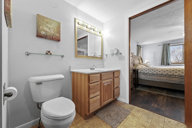 bathroom with vanity, a textured ceiling, and toilet