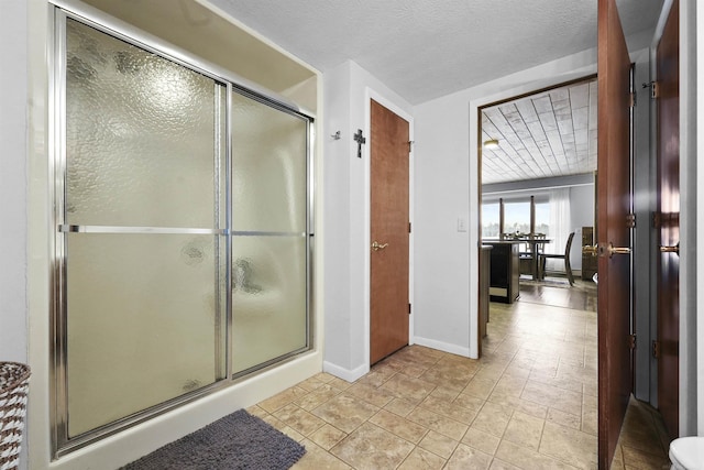 bathroom with a shower with door and a textured ceiling