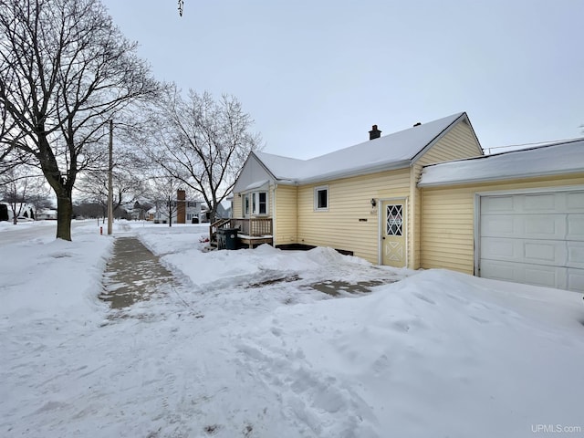 view of snow covered exterior with a garage