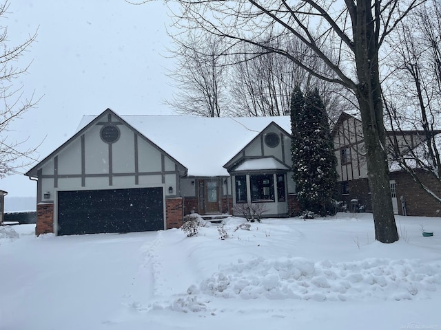 tudor house with brick siding and an attached garage