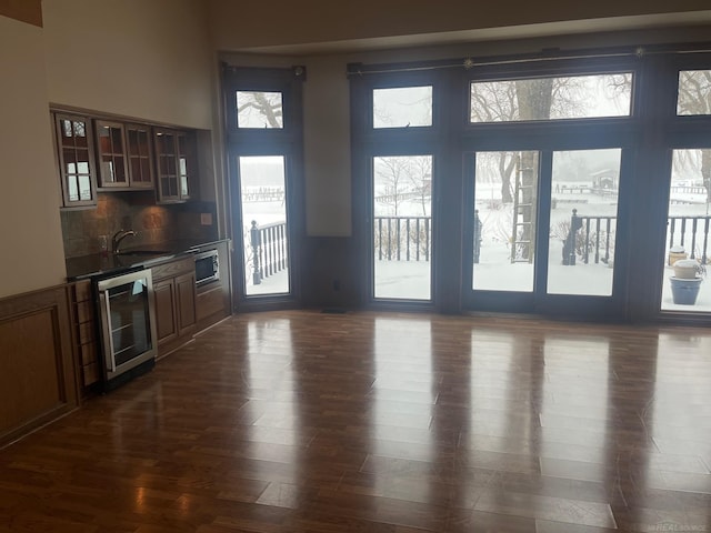 living room featuring sink, dark hardwood / wood-style floors, plenty of natural light, and beverage cooler