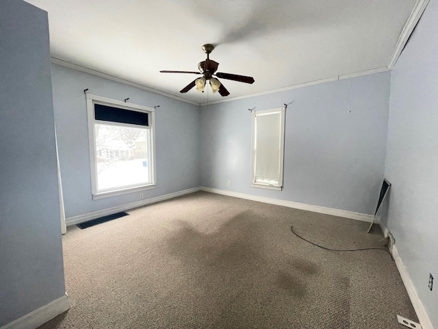 empty room featuring ceiling fan, ornamental molding, and carpet floors