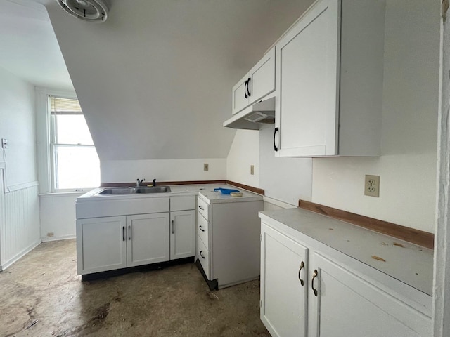 kitchen featuring white cabinetry, sink, and lofted ceiling