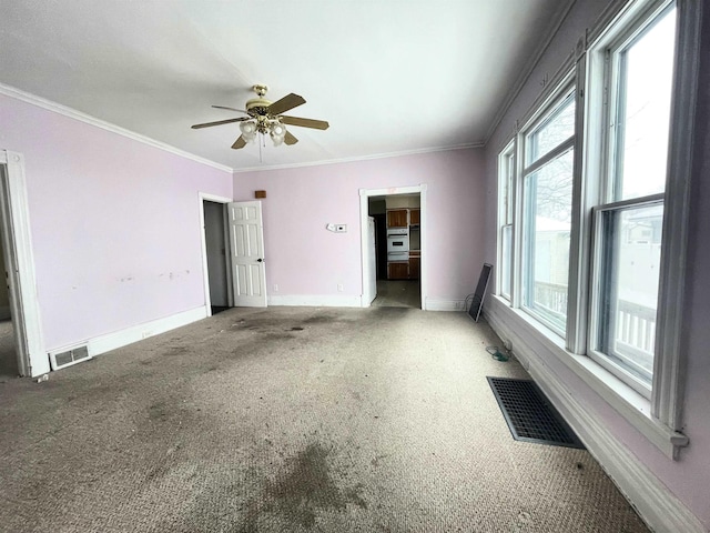 empty room featuring carpet floors, ornamental molding, and ceiling fan