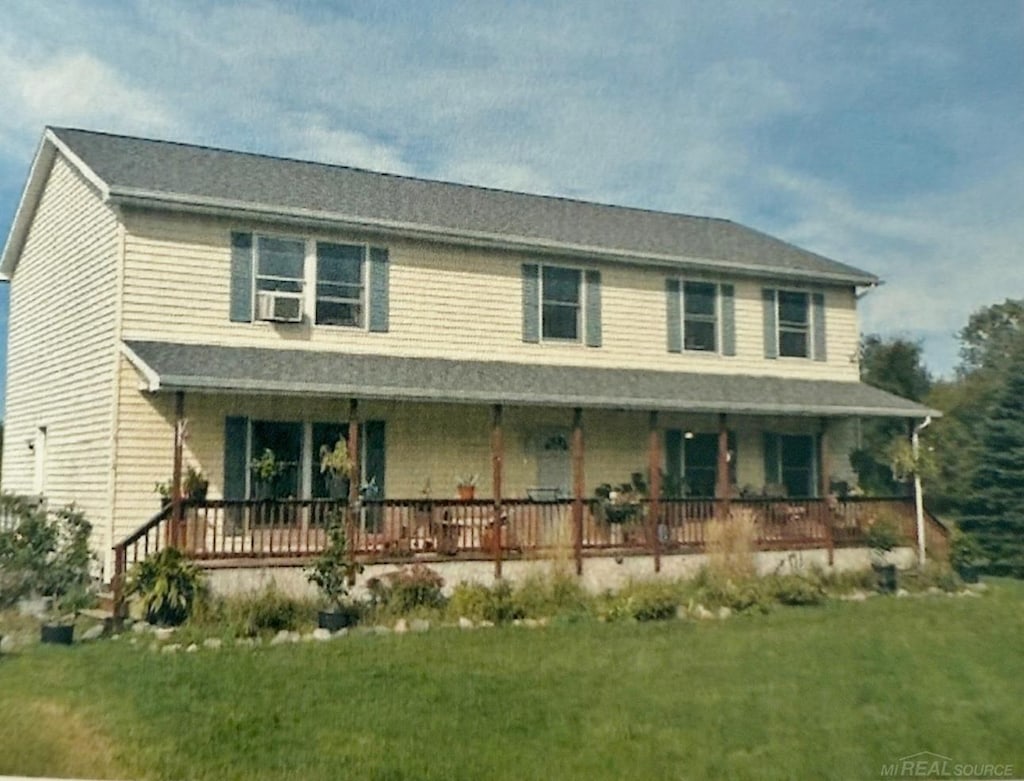 view of front of property with cooling unit and a front yard