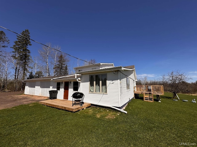 rear view of property featuring a deck, a yard, and dirt driveway