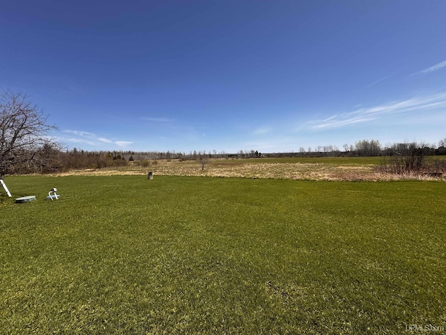 view of green lawn with a view of countryside