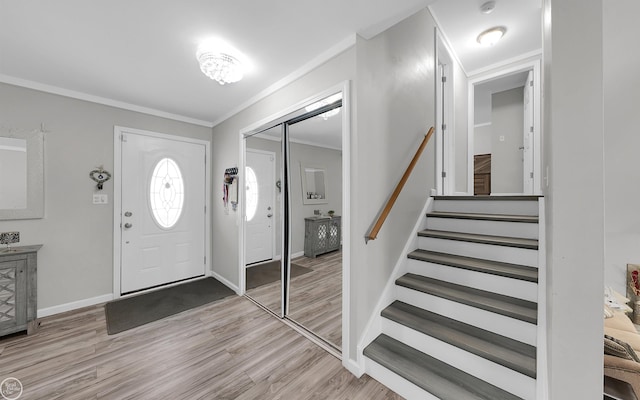 entrance foyer featuring crown molding and light hardwood / wood-style floors