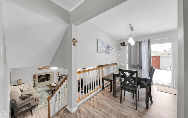 dining space featuring a fireplace and light hardwood / wood-style flooring