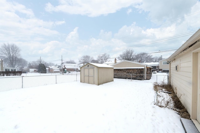 yard covered in snow with a storage shed