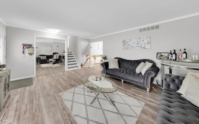 living room featuring ornamental molding and light hardwood / wood-style flooring