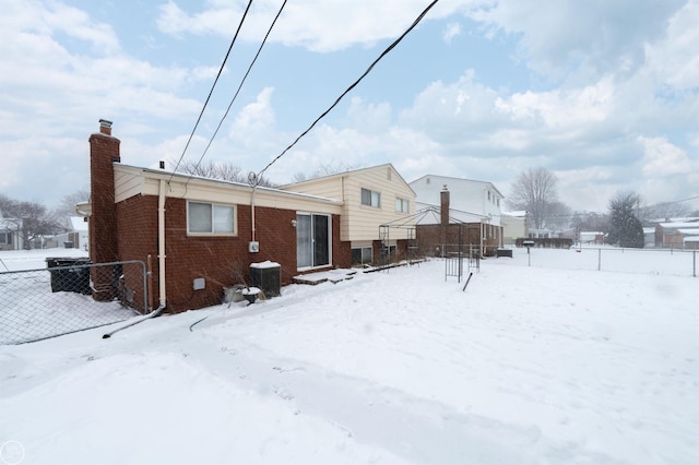 snow covered back of property with central air condition unit