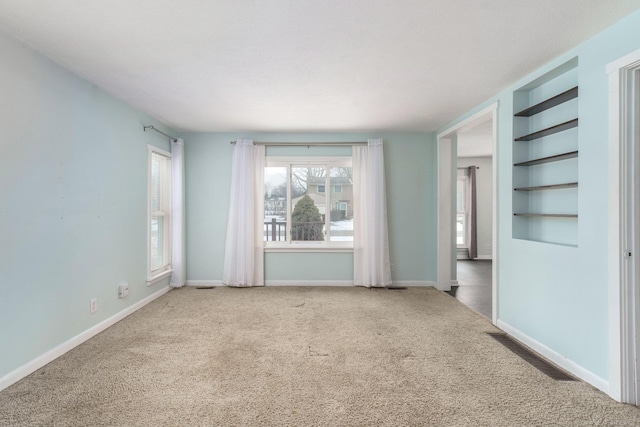 carpeted empty room with built in shelves