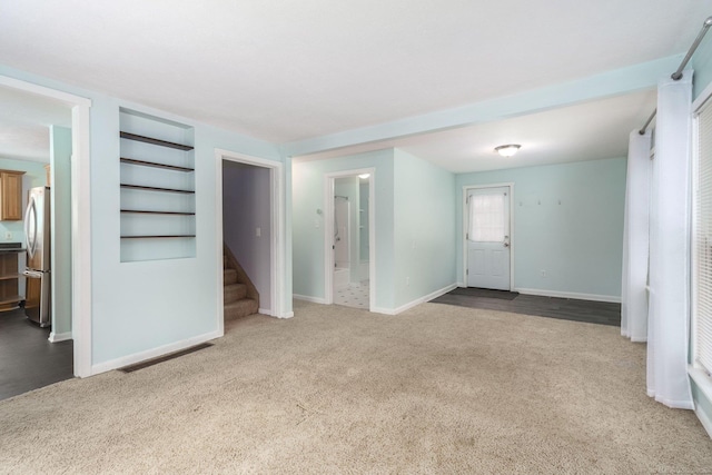 interior space with built in shelves and light colored carpet