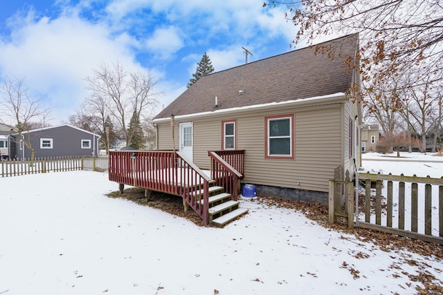 snow covered property with a wooden deck