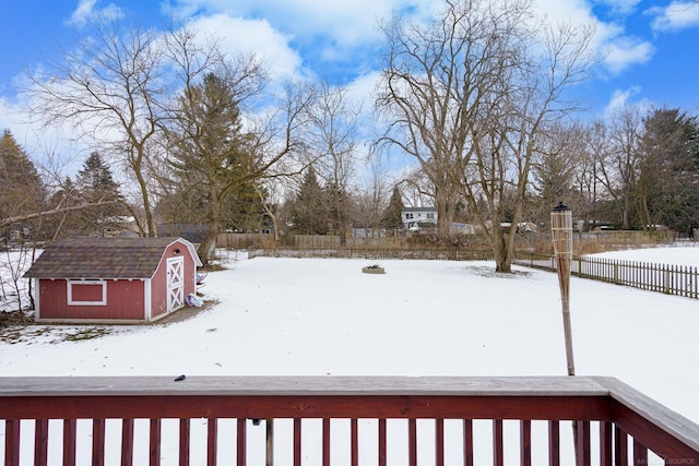 snowy yard featuring a storage unit