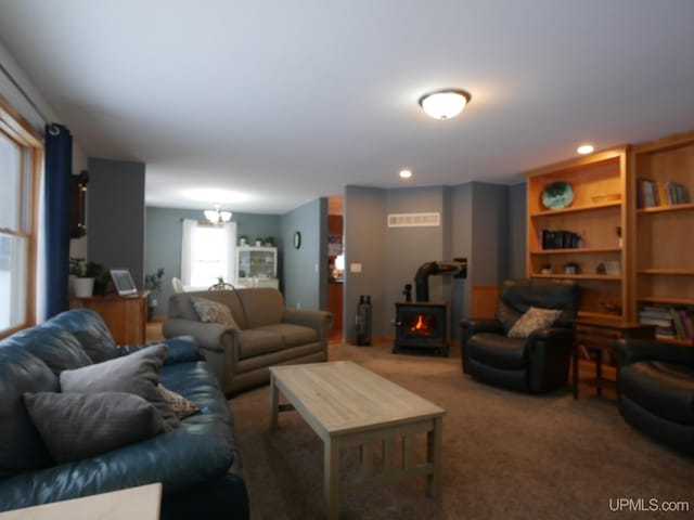 living room featuring carpet floors and a wood stove