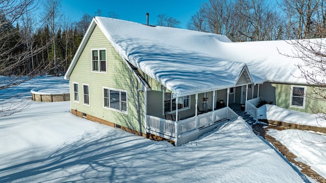 snow covered property featuring covered porch