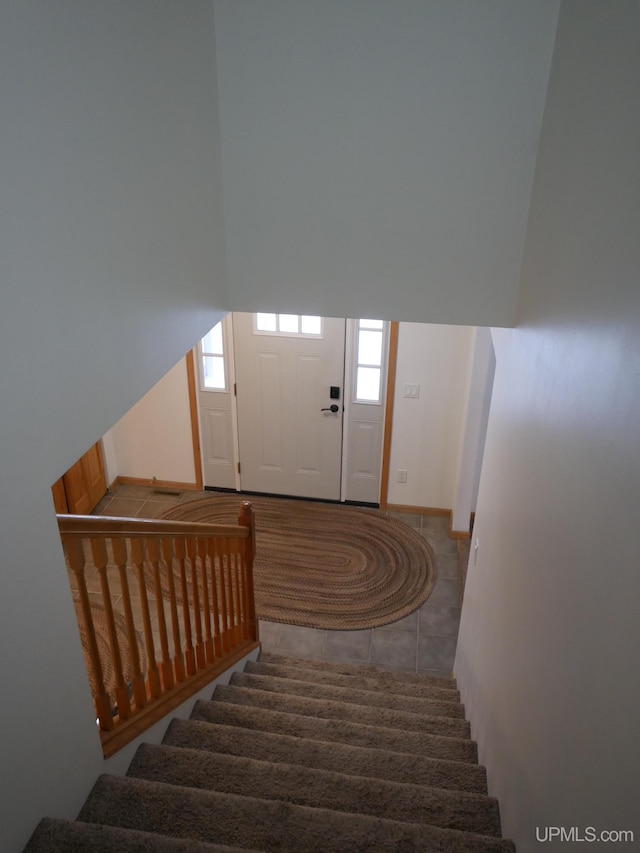 stairs featuring tile patterned flooring and a wealth of natural light