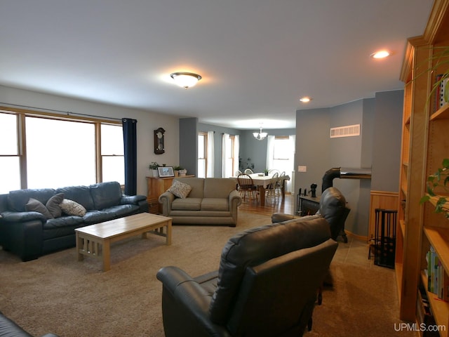 carpeted living room with an inviting chandelier and a healthy amount of sunlight