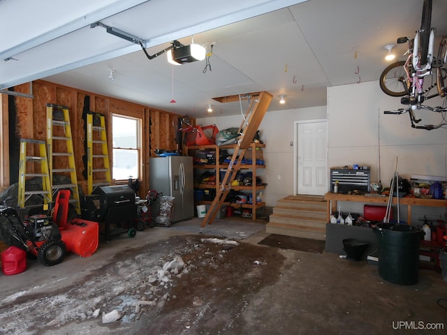 garage featuring stainless steel fridge with ice dispenser, a garage door opener, and a workshop area