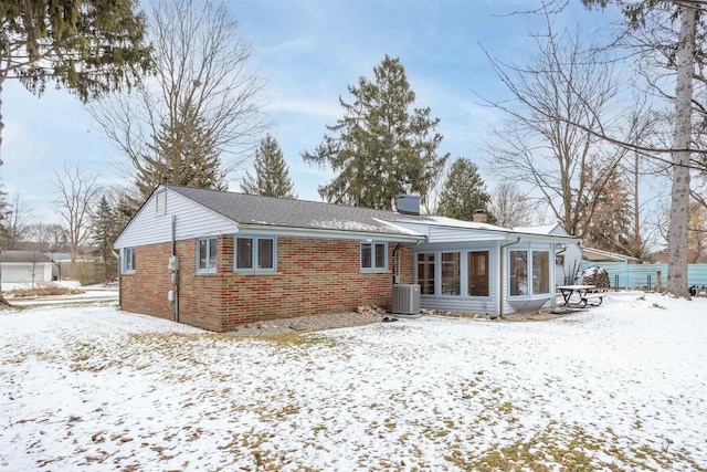 snow covered house with central air condition unit