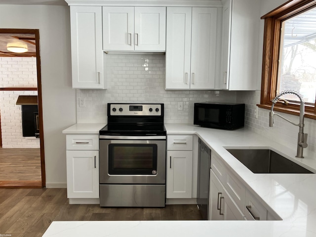 kitchen featuring sink, dark wood-type flooring, stainless steel appliances, tasteful backsplash, and white cabinets