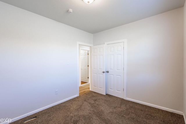 unfurnished bedroom featuring carpet floors and a closet