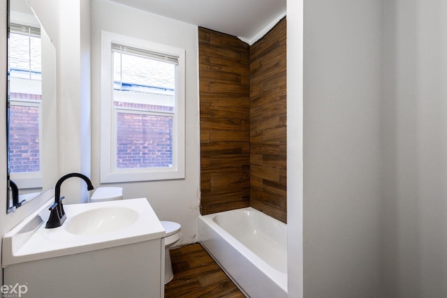 full bathroom with hardwood / wood-style flooring, vanity, shower / bathing tub combination, and toilet