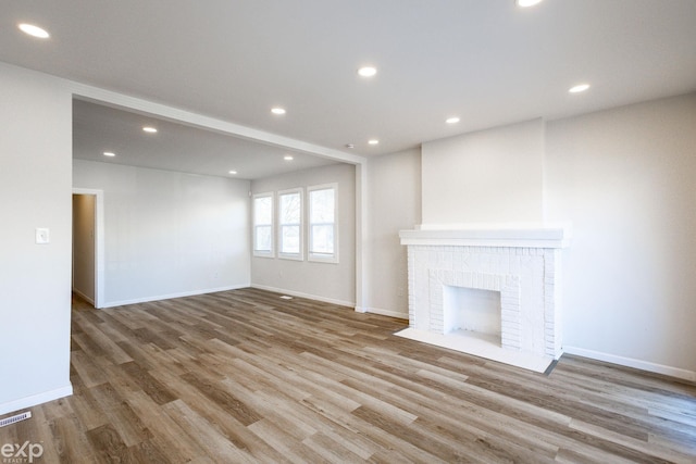 unfurnished living room featuring a fireplace and light wood-type flooring