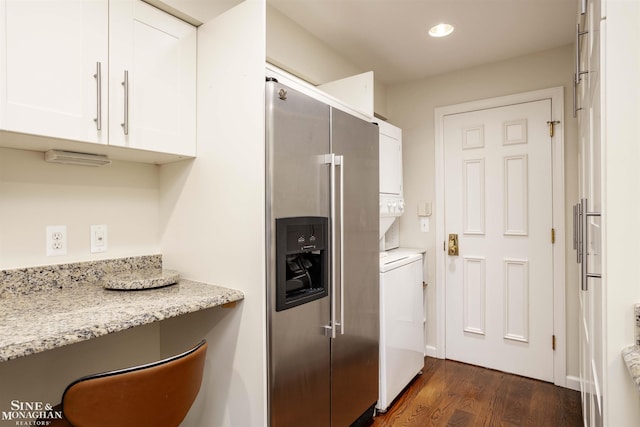 kitchen with stacked washer and clothes dryer, light stone counters, white cabinets, dark hardwood / wood-style flooring, and high end refrigerator