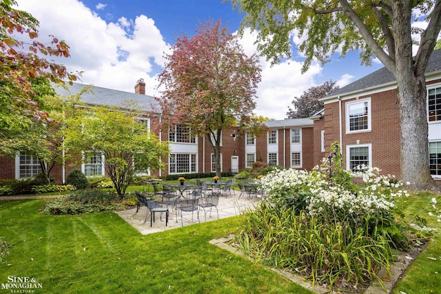 back of house featuring a lawn and a patio