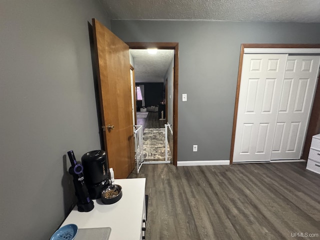 unfurnished bedroom featuring dark hardwood / wood-style floors, a textured ceiling, and a closet