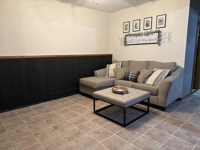 tiled living room with wooden walls and a textured ceiling