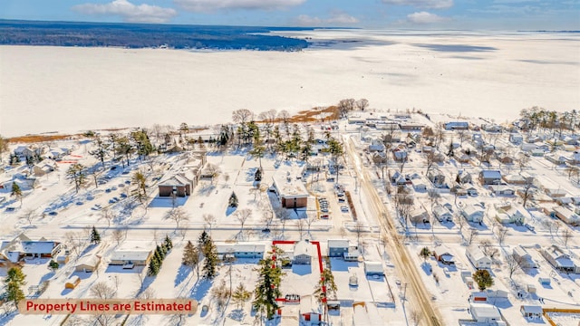 snowy aerial view featuring a water view