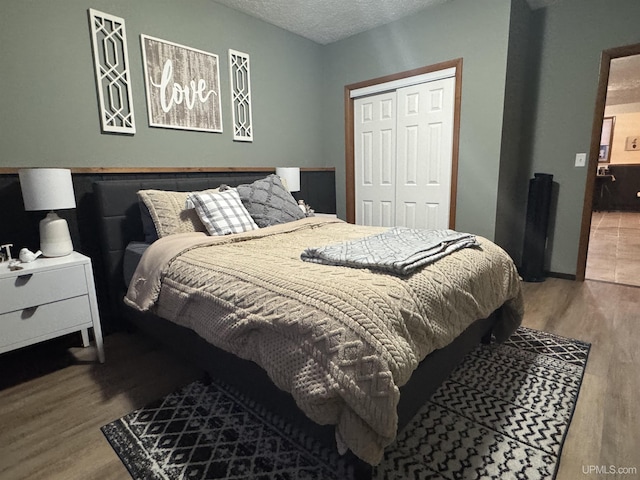 bedroom featuring wood-type flooring, a textured ceiling, and a closet