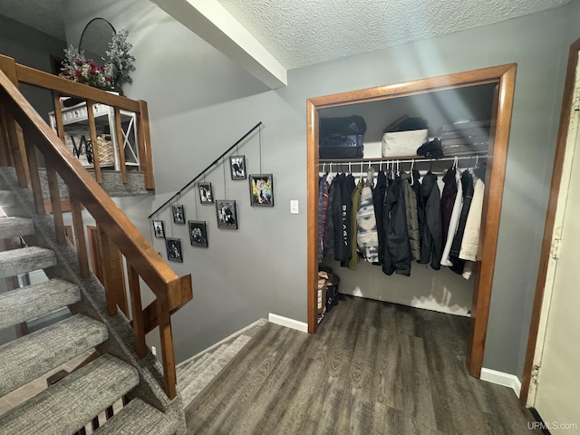 staircase with hardwood / wood-style flooring and a textured ceiling