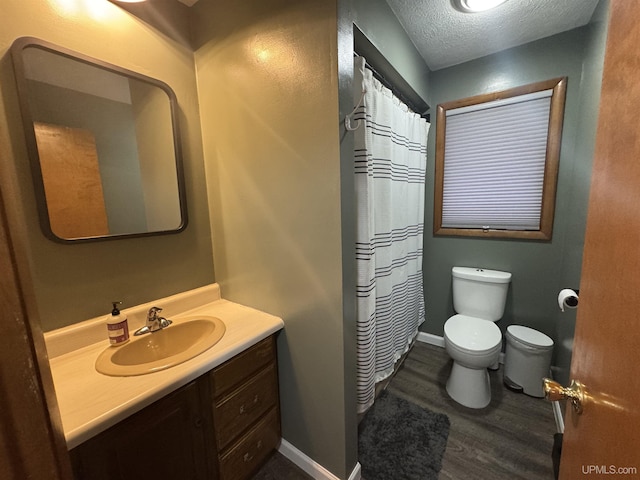 bathroom with vanity, hardwood / wood-style floors, toilet, and a textured ceiling