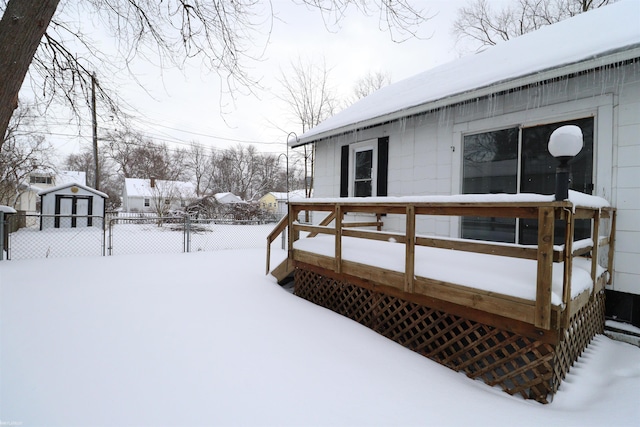 snow covered deck featuring a storage unit