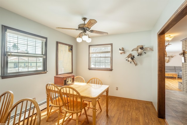 dining space with ceiling fan, light hardwood / wood-style floors, and a baseboard radiator