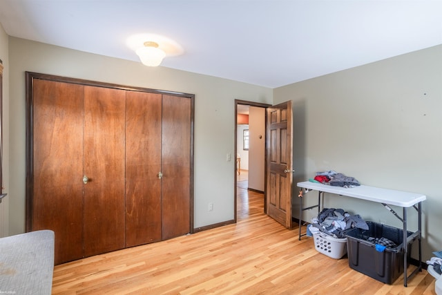 bedroom with light hardwood / wood-style floors and a closet