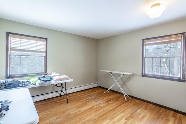 home office with light wood-type flooring and a baseboard heating unit