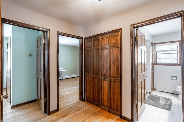 hallway with a baseboard radiator and light hardwood / wood-style flooring