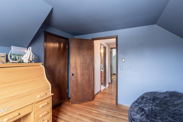 bedroom featuring light wood-type flooring and lofted ceiling